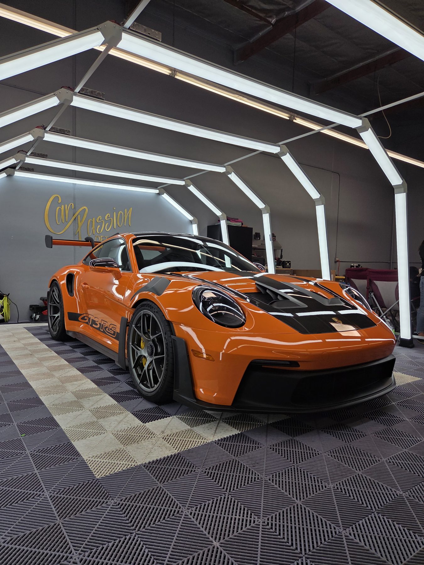 Orange Porsche 911 GT3 RS in the Car Passion Solutions shop in Pomona